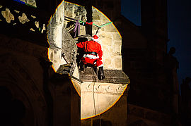 De nuit, le Père-Noël descend de la cathédrale en rappel illuminé par un projecteur. - Irudia handitu (modu-leihoa)
